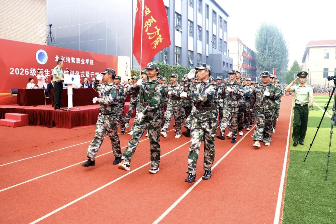 照片：军训结训仪式现场——参训新生在运动场集体展演，背景横幅印有「铭记历史 缅怀先烈 珍爱和平 开创未来」（学院官方微信文章配图，2026-09-19 收录）